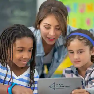 Image of a woman helping two children with a laptop