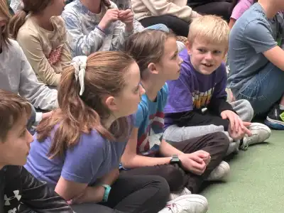 children sitting on a green carpet