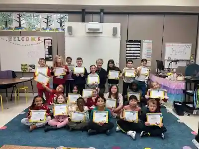 Image of a female volunteer with a student holding a certificate
