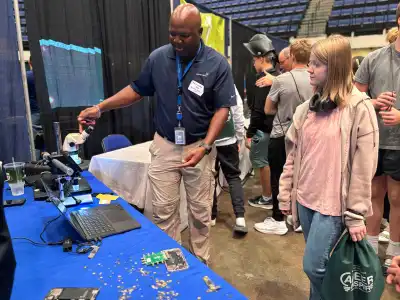 student and volunteer looking at laptop