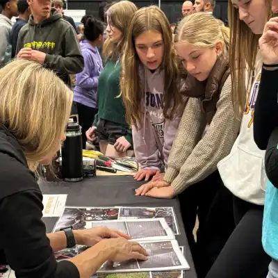 a photo of teens looking at printed documents