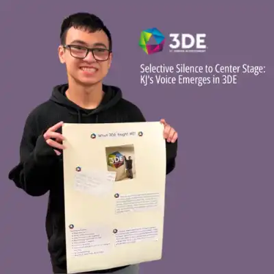 Image of a boy in a black sweatshirt holding a poster