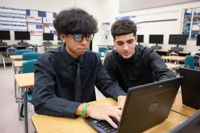 Students working on a laptop.